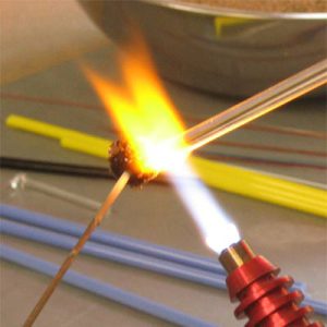 Glaskraal in de vlam Glaskralen worden in een hete vlam gemaakt.