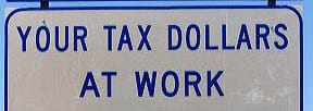 Deel van verkeersbord met de tekst 'Tax dollars at work'