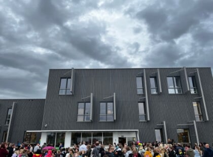 Een schoolgebouw met daarvoor opvallende drukte